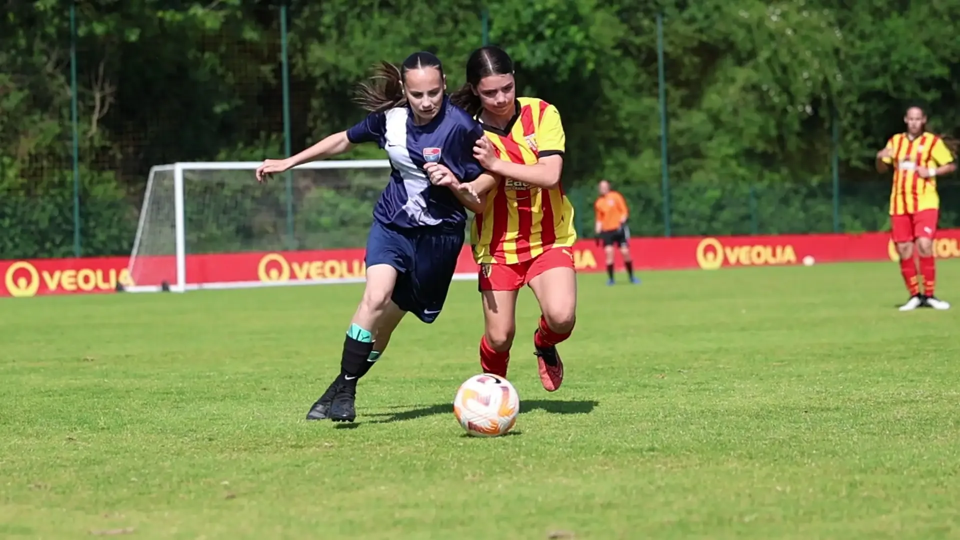Two girls fighting for the ball during a session